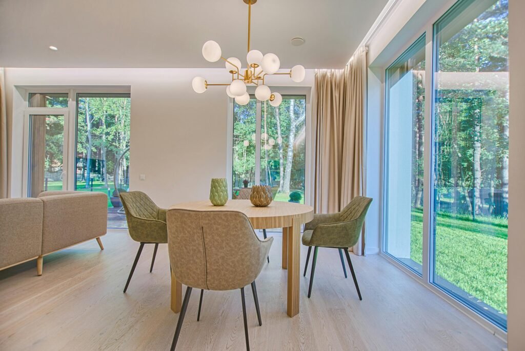 Modern, well-lit dining room with large windows, stylish chairs, and a clean minimalist design, maintained by Modern Cleanings. in Austin Tx